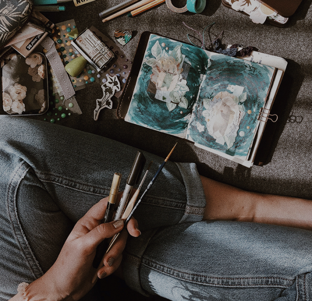 Woman sitting cross legged with brush on hand