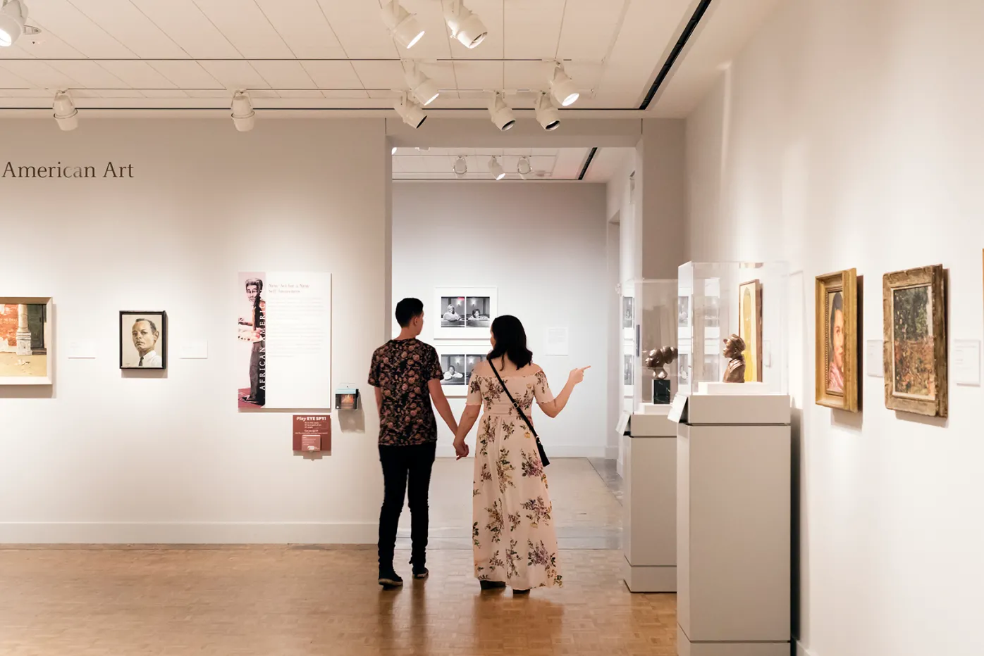 A couple strolling hand-in-hand in the DIA's African American Art galleries