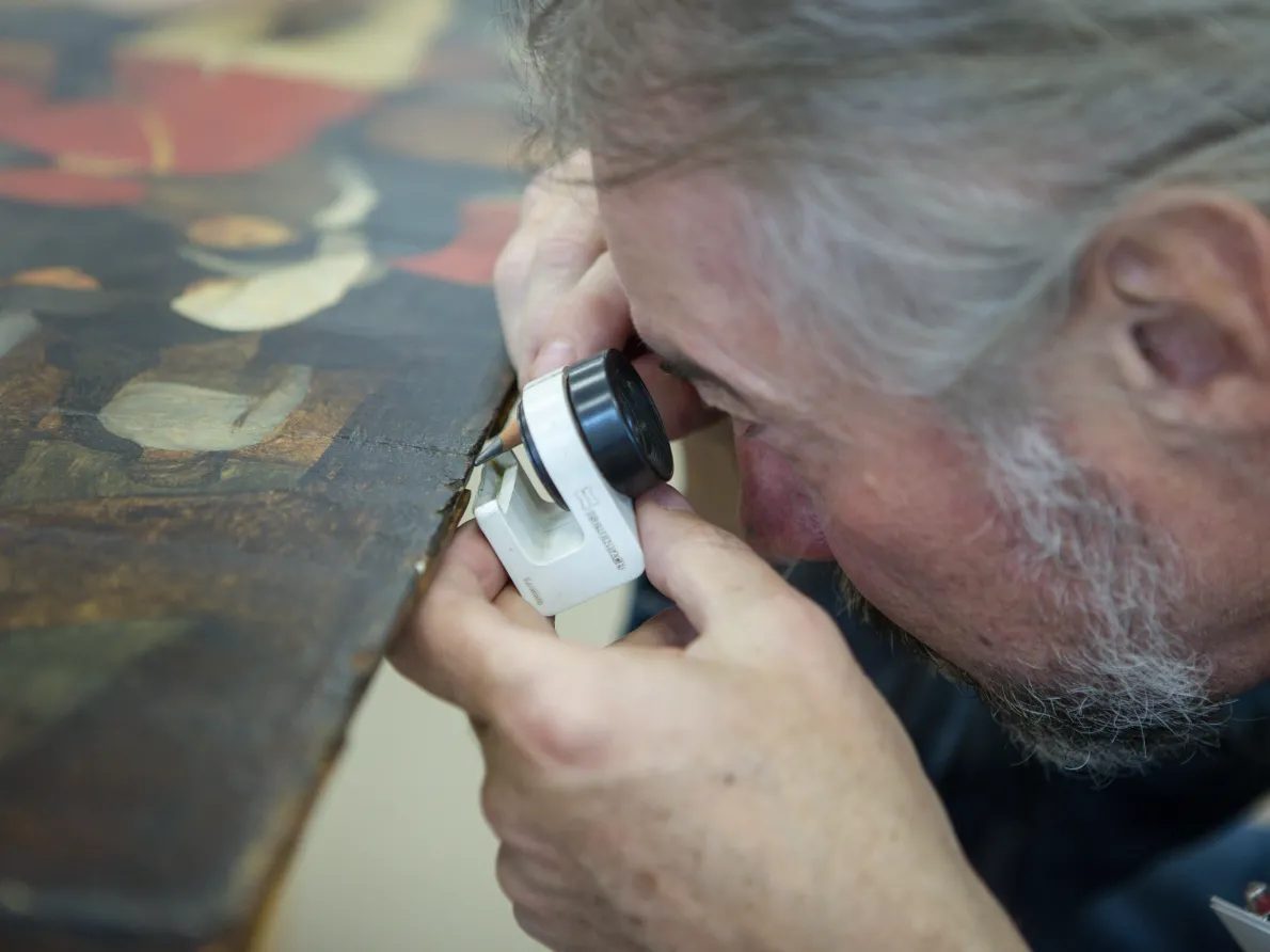 Expert Dr. Tomasz Wazny (Nicolaus Copernicus University in Torun) assesses the edge of wood panel of The Wedding Dance as part of the dendrochronological analysis.