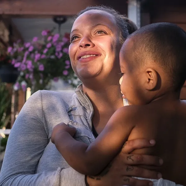 Ashley holds her son Nathaniel on the front porch